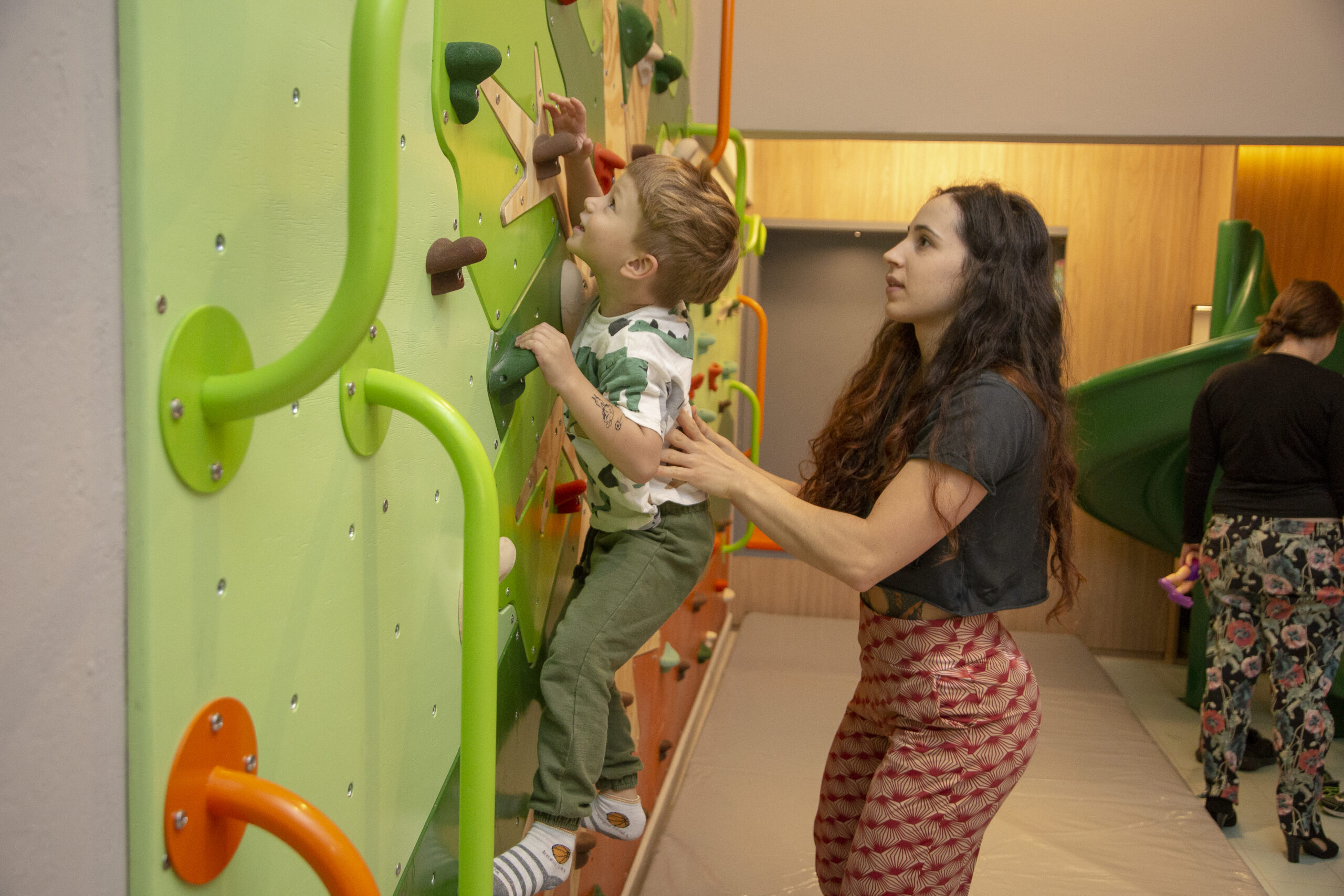 Criança se divertindo em parede de escalada infantil