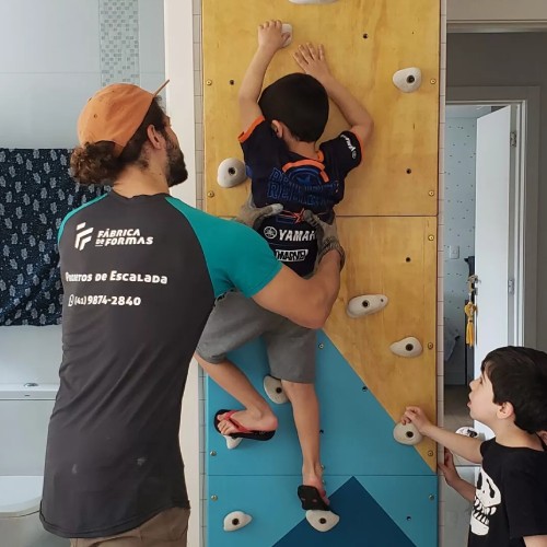 Como criar um espaço de escalada em casa. Duas crianças brincando em uma parede instalada em quarto infantil
